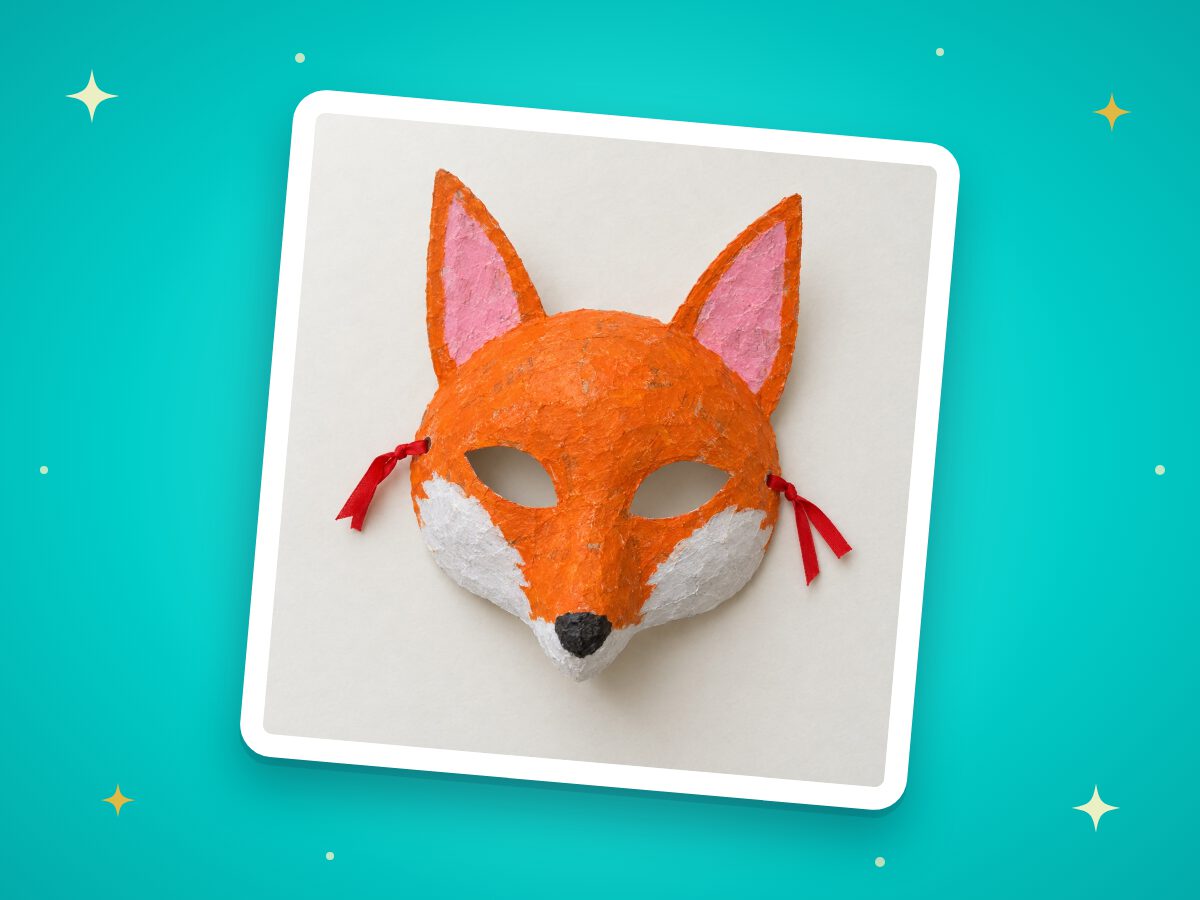 A painted orange fox mask made from paper mache